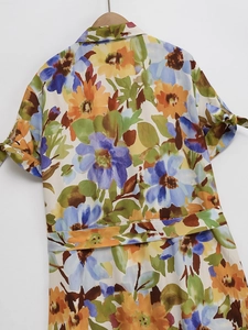 Detail of floral printed dress featuring short sleeves with stylish tie-up ribbon cuffs