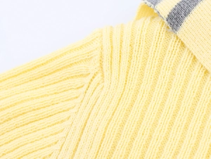 Detailed macro view of yellow ribbed knit texture and grey striped neckline trim