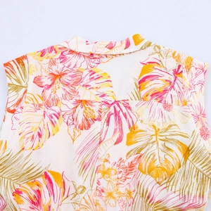 Détail de la robe d'été à col en V avec imprimé floral tropical sur tissu blanc pur
