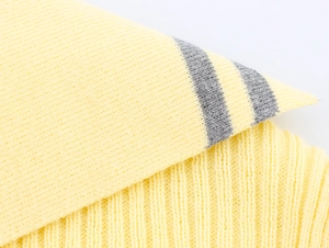 Macro detail of ribbed knit texture with bright yellow and grey horizontal stripe pattern
