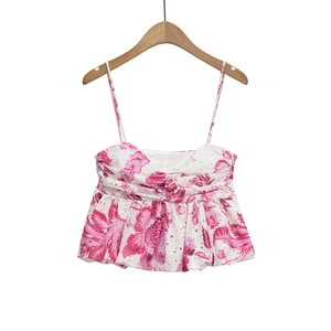 Close-up of white summer top with pink floral print and delicate eyelet embroidery detail