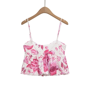 Close-up of white summer camisole with pink floral embroidery and eyelet texture