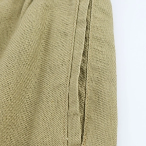 Macro view of khaki wide-leg pants showing breathable linen texture and side stitching
