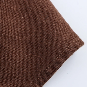Vue macro détaillée de la texture du tissu marron et des coutures fines de la robe midi