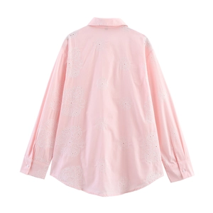 Détail du dos de chemise rose clair avec broderie florale et ourlet arrondi