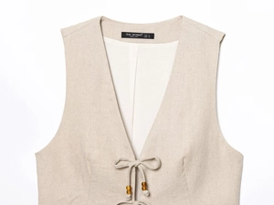 Detail of linen vest with beaded ties and V-neckline on a neutral summer two-piece outfit