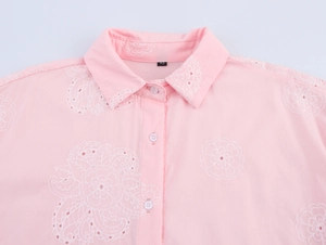 Détail de la chemise rose à manches longues avec broderie florale 3D blanche sur le col