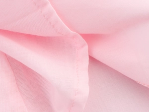 Close-up of pink embroidered fabric texture and stitching details on a mini dress