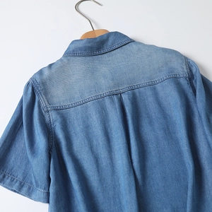 Detail of light blue tencel denim shirt showing back yoke, box pleat and stitching details