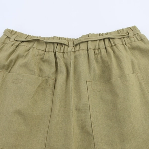 Detail of high waist elastic waistband with drawstring and large pockets on linen trousers