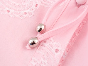 Close-up of pink dress with white embroidery lace and silver beads on drawstrings