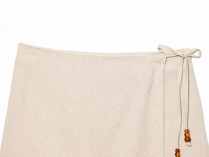 Detailed view of linen blend shorts with drawstring waist and decorative beads