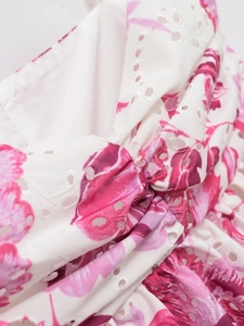 White eyelet embroidery top with pink floral print and twisted knot chest detail