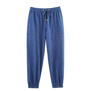 Detail of high waist drawstring with golden metal tips on dark blue joggers