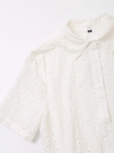 Close-up of white broderie anglaise embroidery detail on summer shirt dress collar