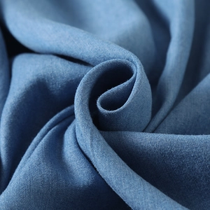 Gros plan sur un tissu sergé bleu montrant la texture fine et les détails tissés