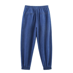 Detail view of high-waist drawstring joggers with elastic ankle cuffs in dark blue denim