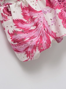 Detailed close-up of summer top featuring pink leaf prints and intricate eyelet embroidery