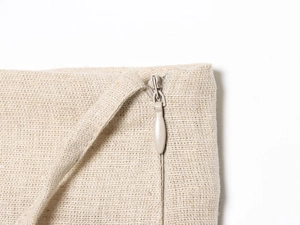 Macro detail of high-quality beige cotton linen fabric and smooth invisible zipper seam