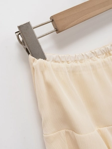 Dettaglio dell'elastico in vita e del tessuto in crepe strutturato sulla gonna midi beige