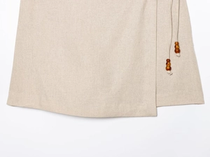 Detail of linen wrap dress ties with polished dark brown beaded tassel accents