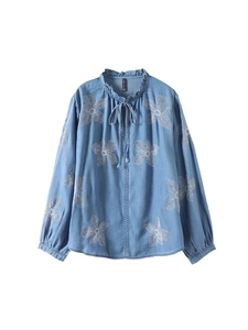 Chemisier bleu clair avec broderie florale, col à volants et lien sur le devant