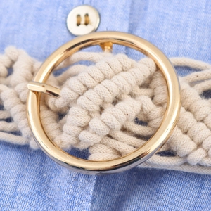 Détail d'une ceinture tressée bohème avec boucle dorée sur robe d'été bleu clair