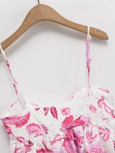 Detail of floral eyelet embroidery on white sleeveless camisole top with thin straps