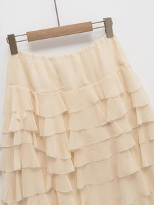 Dettaglio della gonna midi a balze color crema con vita alta elastica e texture fine