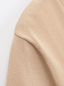 Gros plan détaillé montrant la texture en maille fine et la couture de l'épaule du gilet