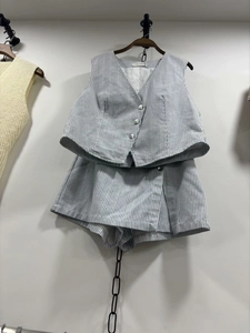 Détail du gilet col V à rayures bleues et blanches avec short taille haute assorti