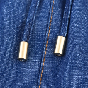 Detailed close-up of dark blue denim drawstring with gold metal tip and orange stitching