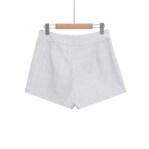 Détail du short à rayures taille haute avec des rayures bleues verticales sur blanc