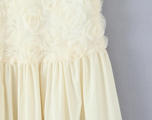 Detailed close-up of 3D floral lace appliques on a sleeveless ivory maxi dress