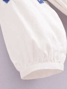 Robe blanche bohème à manches lanternes, broderies florales bleues et pompons