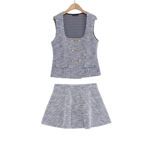 Detail of tweed two-piece set with double-breasted gold buttons and A-line mini skirt