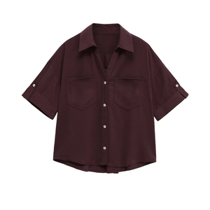 Detail of dark burgundy short sleeve shirt featuring V-neck lapel and front flap pockets