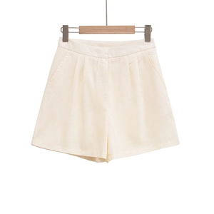 Detailed macro view of cream high-waisted cotton linen shorts with pockets and pleated design