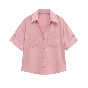 Detailed macro view of pink short-sleeve shirt with lapel collar and dual breast pockets