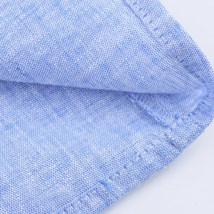 Vue macro du tissu tissé bleu clair montrant les coutures fines de la robe longue d'été