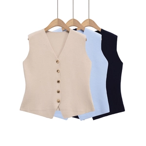Détail de trois gilets en maille à col en V en beige, bleu et marine avec boutons