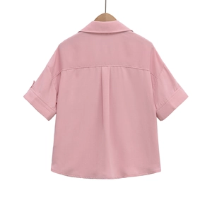Detail view of pink short-sleeve shirt back with rolled cuffs and back pleat design