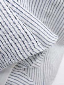 Vue macro d'un tissu à rayures bleues et blanches avec de fins fils argentés