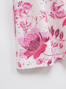 Close-up of Broderie Anglaise hollow embroidery and pink floral print on summer cotton dress