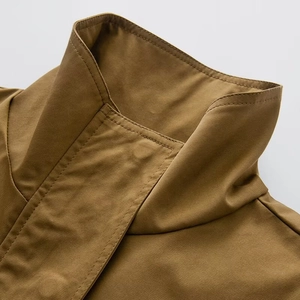 Macro detail of khaki workwear jacket showing stand collar and high-quality fabric texture