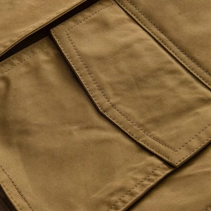 Detailed macro view of khaki twill fabric and reinforced flap pocket stitching
