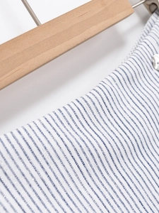 Vue détaillée du tissu à rayures bleues et blanches avec bouton métal et fil scintillant