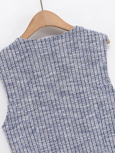 Detail of blue and white tweed fabric with golden threads on a sleeveless vest top