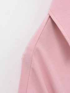 Detail of pink short-sleeve shirt showing clean shoulder seams and notched collar