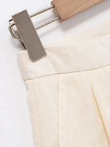Detail of cream vest set showing high-waist pleated design and woven texture fabric
